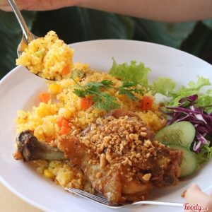 Đĩa cơm chiên vàng rau củ ăn kèm đùi gà sốt mắm tỏi phi và salad